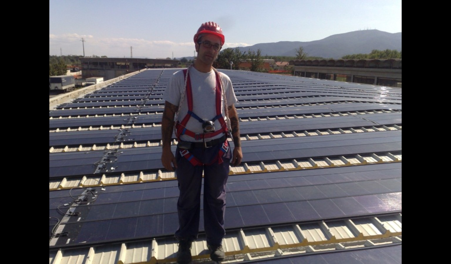 Tecnico con dispositivi anticaduta su un grande impianto fotovoltaico industriale